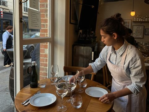 Uitbaatster dekt een tafel in haar bistro.