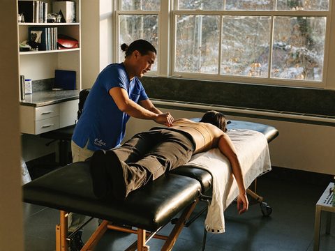 Kinesist behandelt een patiënt in de praktijkruimte.