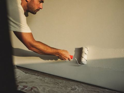 Schilder werkt een muur af.